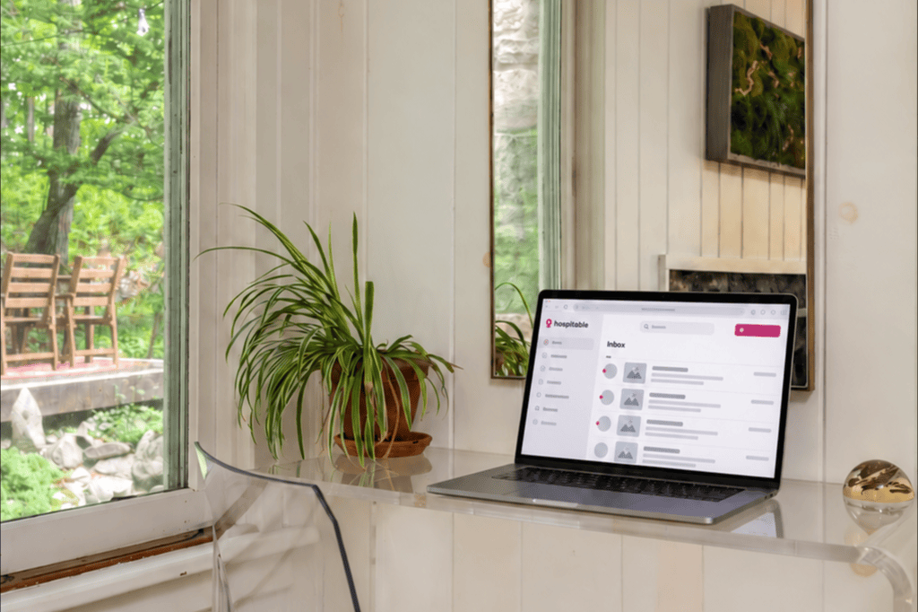 A vacation-rental host workspace with a laptop open to a property-management dashboard